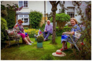A photo of three young at heart village residents enjoying their afternoon teas sitting on a lawn