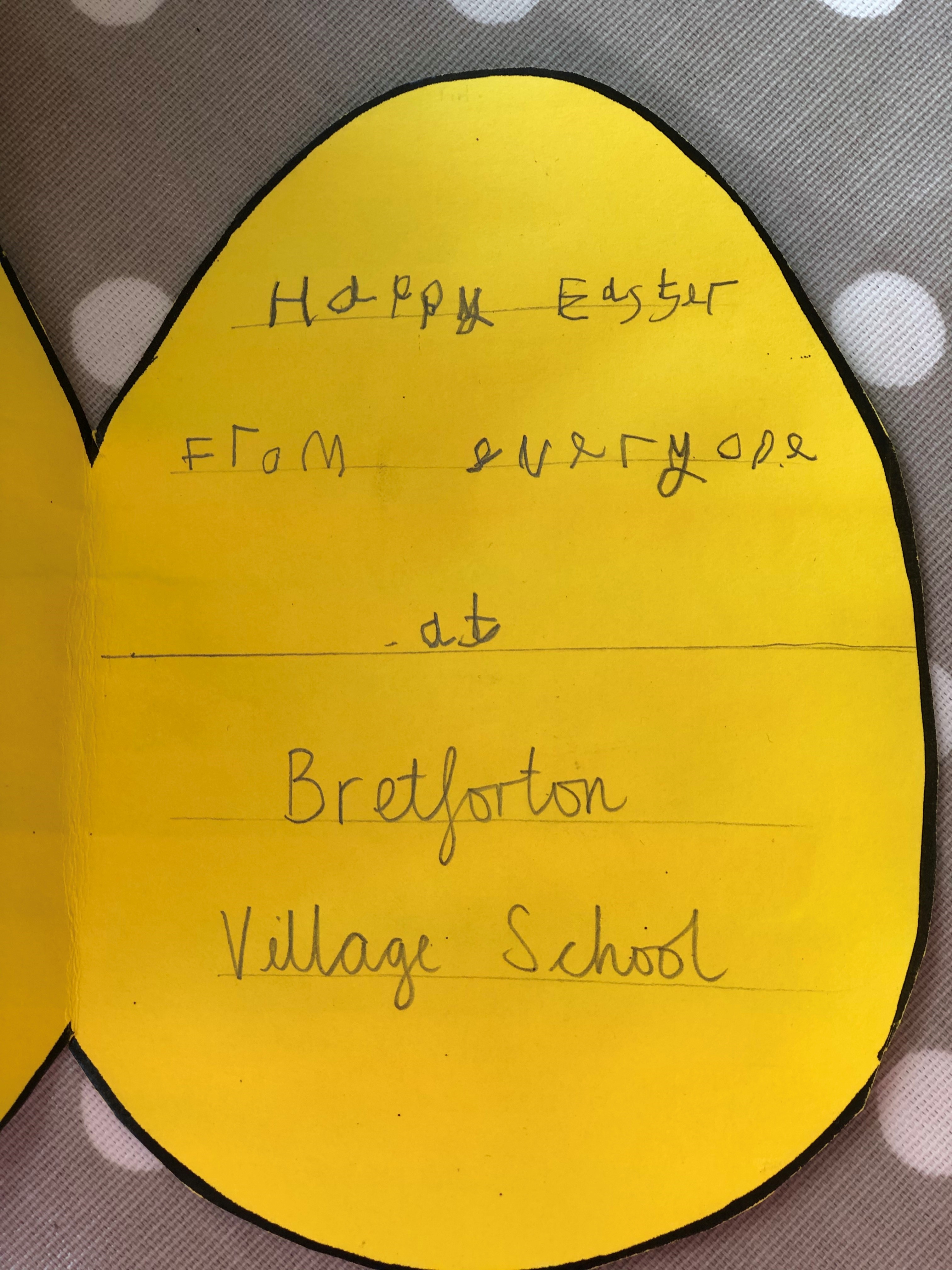Photo of the inside of an egg-shaped yellow Easter card, saying "Happy Easter from everyone at Bretforton Village School"