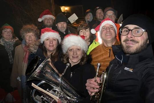 A group photo of members of Bretforton Silver Band wearing Santa hats with their instruments