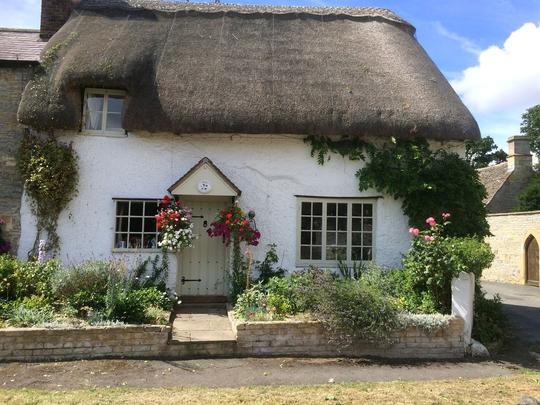 Photo of a pretty white thatched holiday cottage in Bretforton