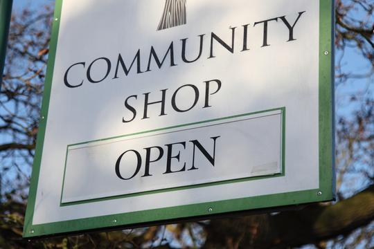 A photo of a sign saying "Community Shop open"