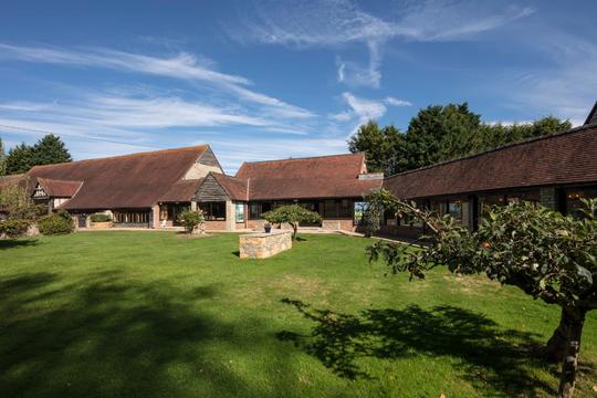 A photo shot across the lawn showing the buildings at Bretforton Theatrebarn