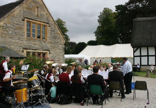 Bretforton Silver Band playing at Bretforton Show outside Bretforton Manor with the Show tent in the background